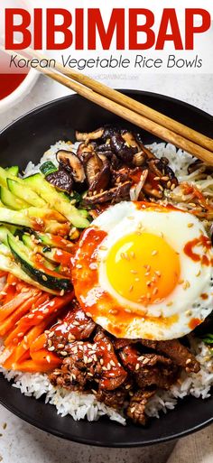 a plate filled with rice, meat and vegetables next to chopsticks on the side