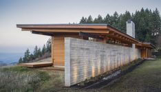 the exterior of a modern house with wood and stone sidings on top of it