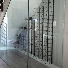 an image of a glass door with wine racks on it's side and stairs in the background