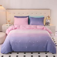 a bed with pink and blue sheets on it