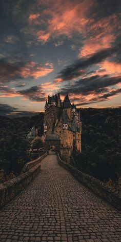 an image of a castle that is in the sky with clouds above it and cobblestone walkway leading up to it