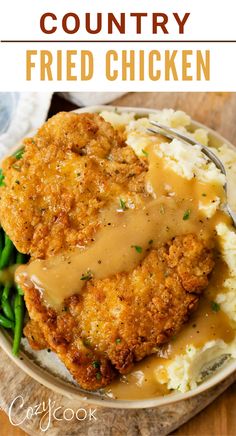 chicken fried in gravy with mashed potatoes and green beans on a plate