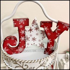 a white basket with red letters and snowflakes