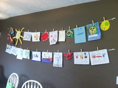 there are many pictures hanging on the clothesline with paper clips attached to each one