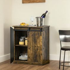 a wooden cabinet sitting in the corner of a room next to a chair and table