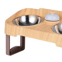 two bowls with spoons in them are on a wooden tray that is attached to a metal holder