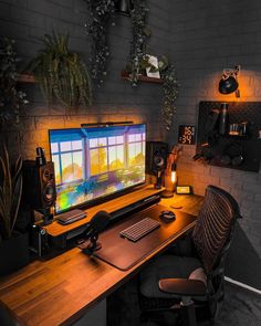 a computer desk with a monitor and keyboard on it in front of a brick wall