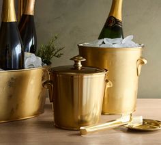 two champagne bottles and ice buckets on a table