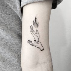 a hand holding a flame tattoo on the left forearm and arm, with two hands reaching for it