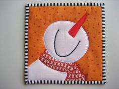 an orange and black square with a white snowman on it