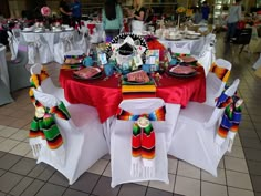 a table set up for a mexican themed party with plates, napkins and decorations