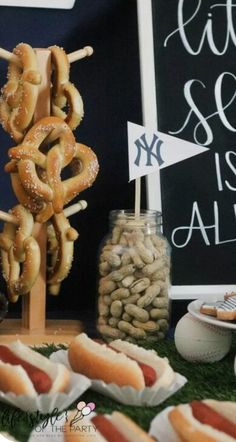 hot dogs, pretzels and other snacks are on display at a sports themed birthday party