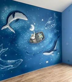 a child's room with blue walls and dolphins painted on the wall, along with a wooden floor