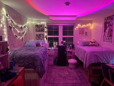 a bedroom with two beds and lights on the ceiling above them is lit up by purple lighting