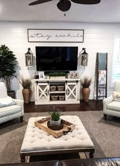 a living room filled with furniture and a flat screen tv mounted on the wall above it