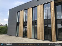 a large building with lots of windows and wood panels on the side of it's face