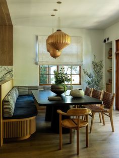 a dining room table with chairs and a bench in front of a window that is open to the outside