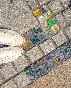 a person standing on the sidewalk with their feet up and wearing tennis shoes in front of them