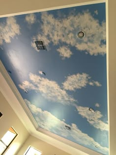 the sky is painted on the ceiling and it looks like clouds are floating in the air