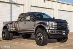 a large black truck parked in front of a building