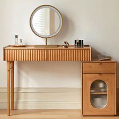 a wooden table with a mirror on top of it next to a drawer and cabinet