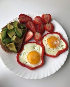 an egg, avocado and strawberries are on a paper plate with toast