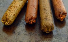 four different types of sausage sticks on a counter top, one is brown and the other is orange