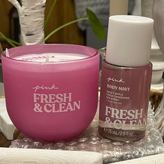 a bottle of fresh & clean next to a pink container on a table with other items