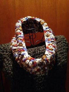 a crocheted multicolored scarf is on display