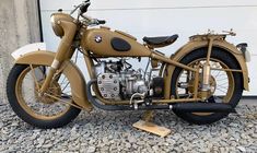 an antique motorcycle is parked in front of a garage