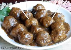 meatballs with sauce and toothpicks in a white bowl on a tablecloth