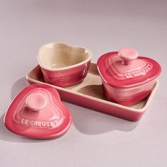 two heart shaped dishes on a tray with the lid open and one bowl in the shape of a heart