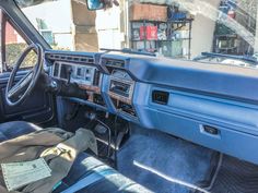 the interior of a car with blue leather seats and dash board, including steering wheel