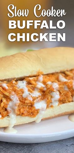 a close up of a sandwich on a plate with the words slow cooker buffalo chicken