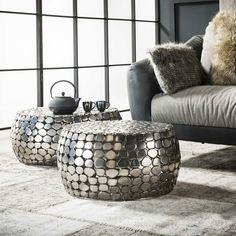 two coffee tables sitting on top of a rug next to a couch