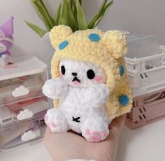 a hand holding a small crocheted stuffed animal