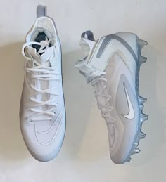 a pair of white nike shoes hanging on a wall