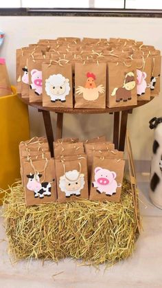 some brown bags with farm animals on them sitting in hay next to a cow vase