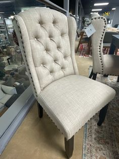 a pair of beige chairs sitting on top of a rug