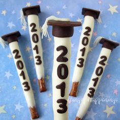 four graduation cake sticks with the numbers 2013 - 2013 written on them in white icing