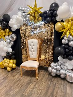 a chair sitting in front of a birthday backdrop with balloons and stars on the wall