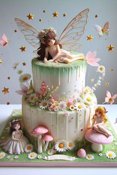 a cake decorated with fairy figurines and flowers