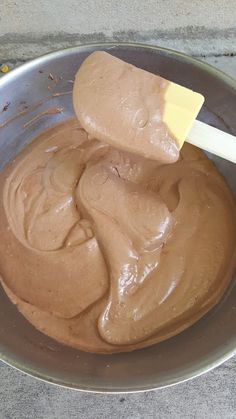 a spoon in a metal bowl filled with chocolate