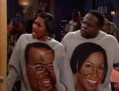 two people wearing sweatshirts with faces on them