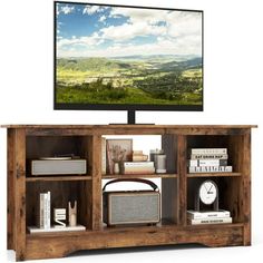 a flat screen tv sitting on top of a wooden entertainment center next to a book shelf