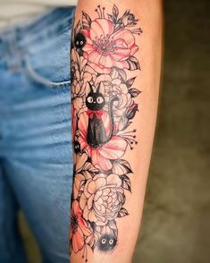 a woman's arm with flowers and an elephant tattoo on the left side of her arm