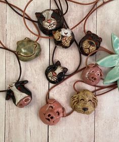 several different animal heads are hanging from a string on a white wooden surface with a blue flower