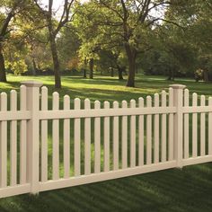 a white picket fence is in the grass