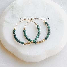 Malachite Gold Hoop Earrings D E T A I L S These gorgeous hoop earrings are created with Genuine Natural Malachite 3mm beads beaded by hand  14kt gold filled 35mm hoops and accents  ∙ EXTRA LOVE ∙ Crafted and curated just for you in the desert of our Arizona studio. All of our jewelry comes gift packaged!  We are happy to leave a note if this is a special gift, just let us know in the message box at checkout.  PRODUCTION ∙ TIMES All items are made to order. Please check the top of our policies p Green Hoop Earrings With Natural Stones For Gift, Malachite 8mm Beads Jewelry Gift, Malachite Jewelry With Round Natural Stone Beads, Bohemian Malachite Round Beads Jewelry, Luxury Elegant Malachite Earrings, Elegant Malachite Earrings, Malachite Earrings, Malachite Jewelry, Gem Necklace