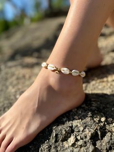 This is a cowrie shell anklet with gold details and a small whale tail charm. It is an elegant adjustable shell anklet perfect for the summertime! Crowrie shells are viewed as symbols of womanhood, feminity, and wealth. Combination with gold increases their feminity. This cowrie shell anklet goes great with many other golden shell accessories. Take a look at the bracelet, necklace, choker, and earrings you'll find in my shop as well. Each piece comes in custom Orca Legacy gift packaging, with a Adjustable Dainty Anklet For The Beach, White Starfish Charm Anklet For Beach, Handmade Strand Anklets, White Beach Anklets With Starfish Charm, Summer Anklet With Starfish Charm As Gift, Summer Beach Anklets With Starfish Charm, Beachy Anklets As Gift, Gold Anklet For Summer Vacation, Summer Vacation Shell With Starfish Charm